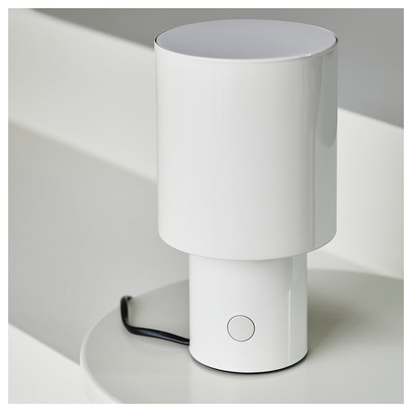 En elegant, vit bordslampa med en cirkulär på/av-knapp. Elegant design, modern estetik.