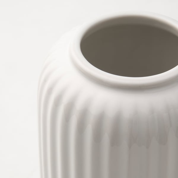 Vit vas med strukturerad, räfflad yta, ren, minimalistisk design.