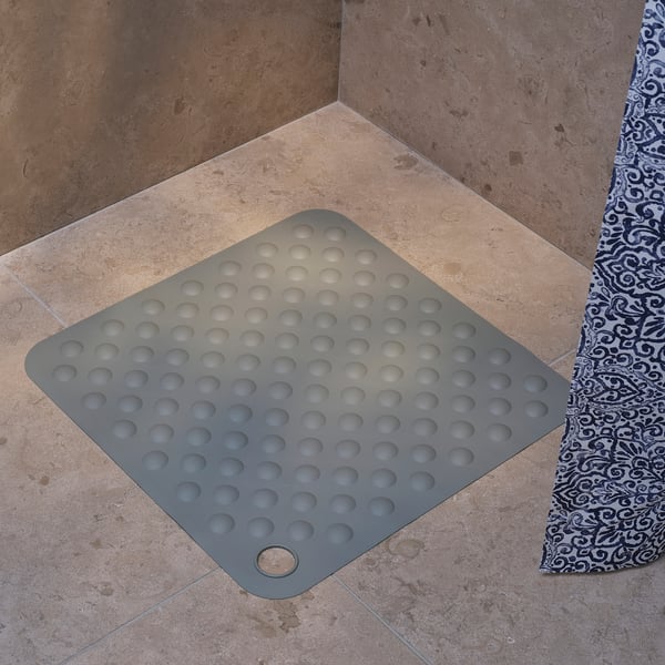 Fyrkantig grå duschmatta med sugkoppar, designad för halkfri säkerhet.