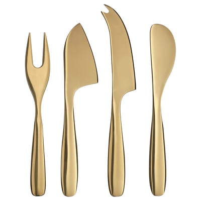 Fyra eleganta, mässingsfärgade serveringsredskap: gaffel, kniv, spatel och ostkniv, var och en med eleganta, metalliska handtag och spetsar i rostfritt stål.