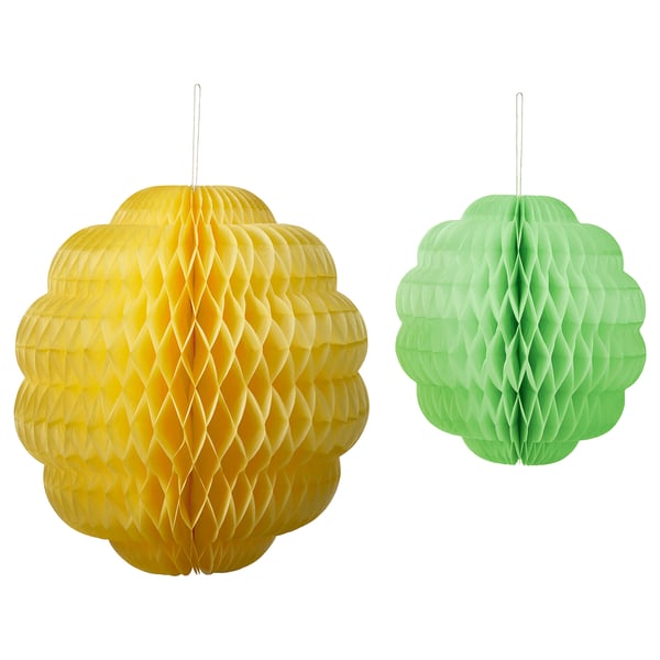 Två papperslyktor hänger, gula och gröna, sexkantig design.