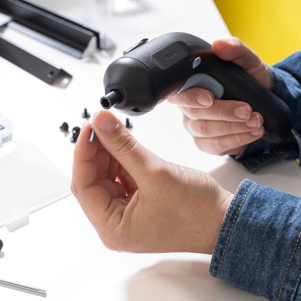 Person använder kompakt TRIXIG skruvmejsel med magnethållare och led-ljus, perfekt för gör-det-själv-uppgifter.