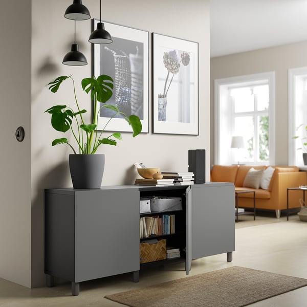 Modernt vardagsrum med grått sideboard, förvaring och växt.