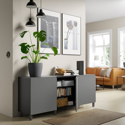 Modernt vardagsrum med grått sideboard, förvaring och växt.