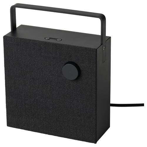 Svart bärbar bluetooth-högtalare med handtag, cirkulär kontrollknapp och tygöverdrag.