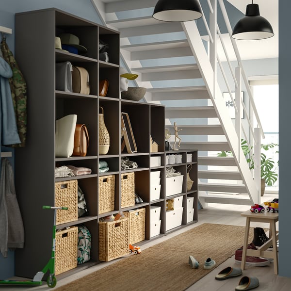 Modern förvaring VIHALS med hyllor, korgar och böcker. Minimalistisk design i svart och naturliga färger, effektivt utrymme under trappor.