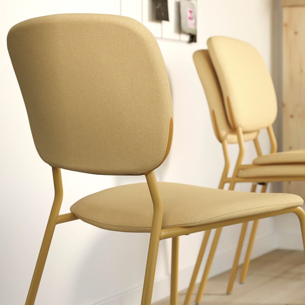 Staplade stoppade stolar med guldramar och vadderade sitsar, designade för komfort och stil.
