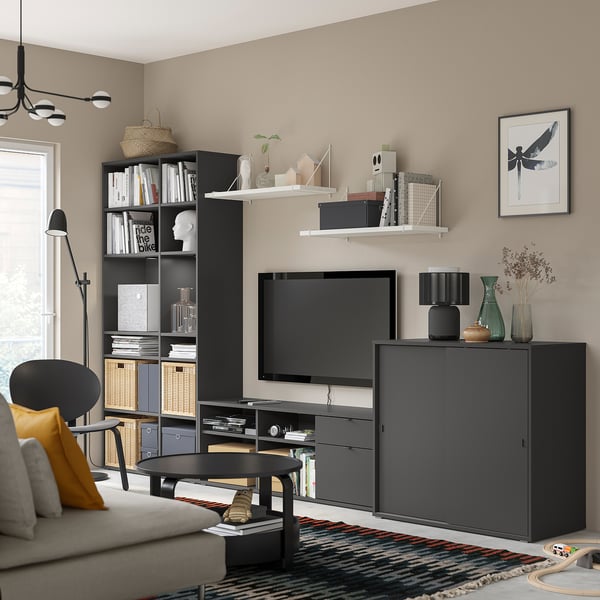 Modernt vardagsrum: svarta VIHALS förvaringsenheter, tv, soffa och inredning. Ren, sammanhållen design.