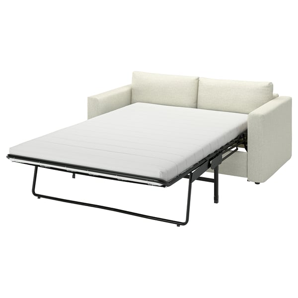 En beige VIMLE-bäddsoffa med metallram, cabrioletdesign och tjock madrass.