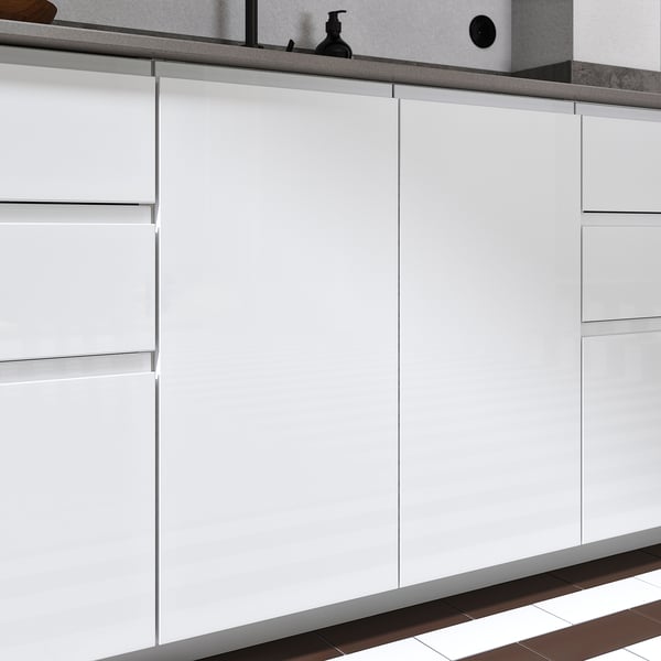 Moderna köksluckor med vit högblank finish och integrerade handtag, vilket ger ett elegant och rymligt utseende.