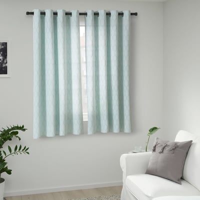 Light blue ADELHILD curtains with white pattern hang near white chair and plant. Cotton material, elegant medallion design, fully covers small window.
