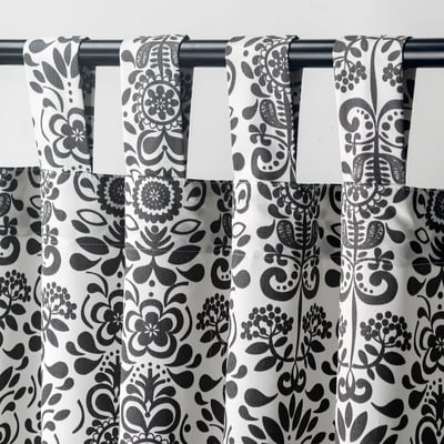 Black & white patterned curtains with floral motifs, tab headings, philtre light, provide privacy.
