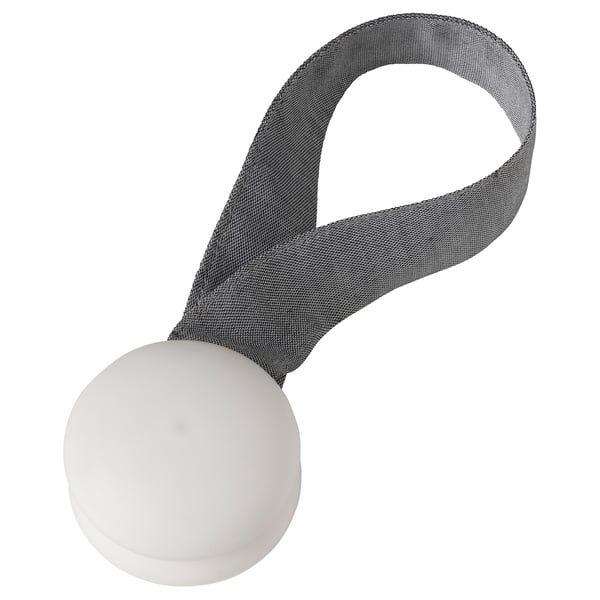 Grey fabric tie-back with white magnetic ends, holding curtains without holes.