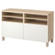 A BESTÅ tv bench in light oak and white. It open shelves and cabinetry for storage, with a minimalist design.