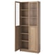 A BILLY bookcase with a light brown finish, featuring adjustable shelves and glass doors, perfect for displaying or hiding items.