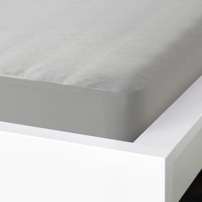 A fitted grey bed sheet with elastic edges neatly covering a white mattress on a bed frame.