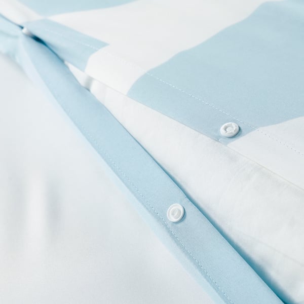 A light blue buttoned sheet set, featuring a close-up of a button and folded corner of a duvet cover, highlighting the brushed, soft fabric.