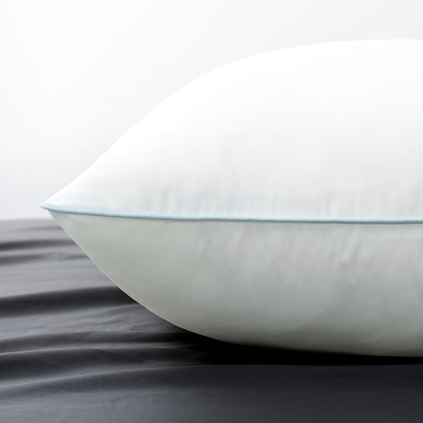 Close-up of soft, white pillow with smooth texture and neat stitching, showing high-quality design.