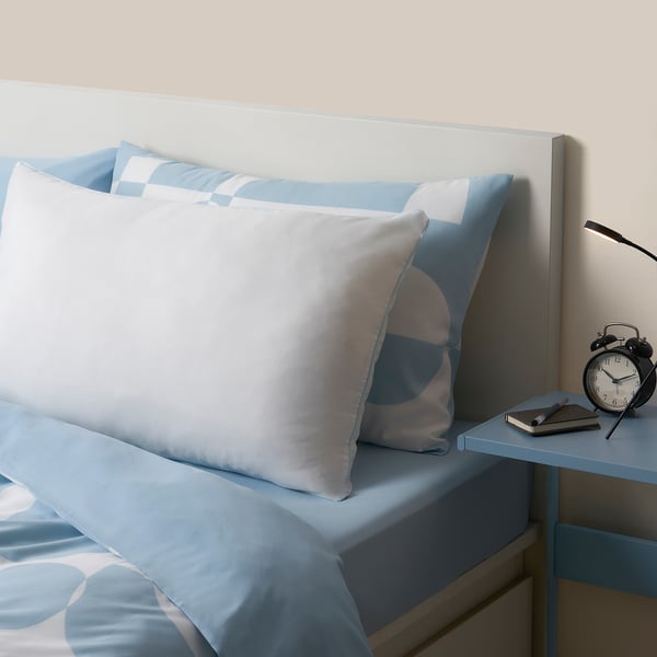 Blue BRUKSVARA pillow on bed, large, recycled microfiber & polyester filling.