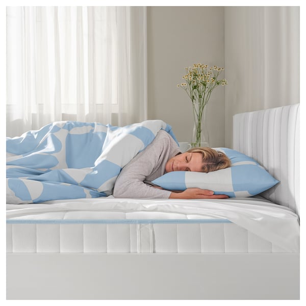 Sleeping on BRUKSVARA bed with blue-white bedding, flowers, soft light