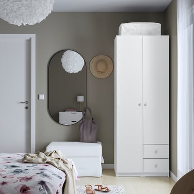 Modern bedroom with BRUKSVARA wardrobe, mirror, floral bed, minimalist decor.