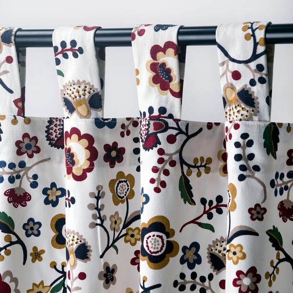 Curtained window with floral pattern; tab headings for direct curtain rod hanging.