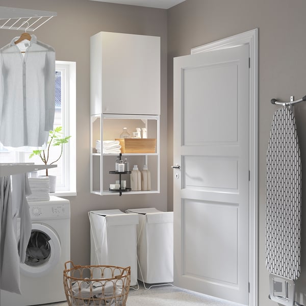 Modern white ENHET laundry setup: tall cabinet, open shelving, washing machine, baskets, and ironing board.