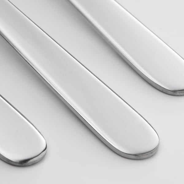 Four polished, shiny, stainless-steel forks arranged neatly, reflecting light, showing high quality and clean design.