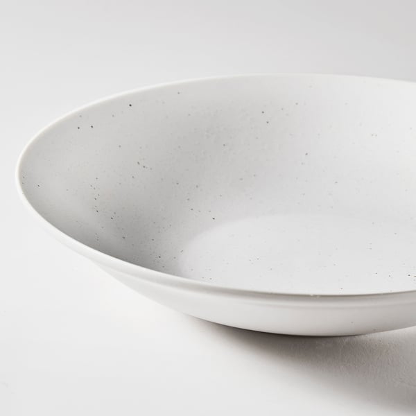 Smooth, white porcelain bowl with subtle flecks, displayed against a white surface.