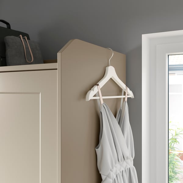 HAUGA wardrobe: sliding doors, hangers & shelves. Dress on hanger, safety wall fitting.