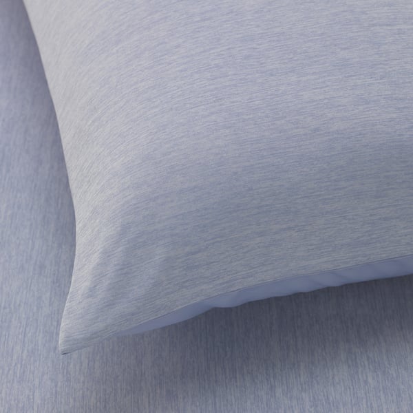Close-up of soft, textured pillowcase on bedding, showing its smooth fabric and quality stitching.