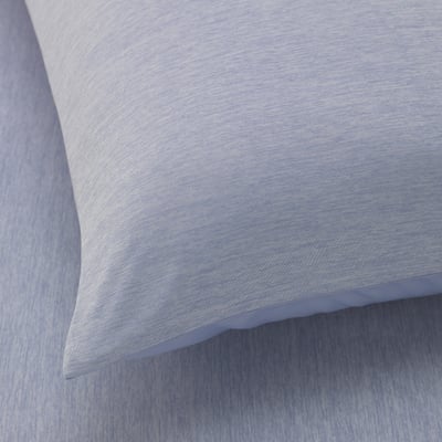 Close-up of soft, textured pillowcase on bedding, showing its smooth fabric and quality stitching.
