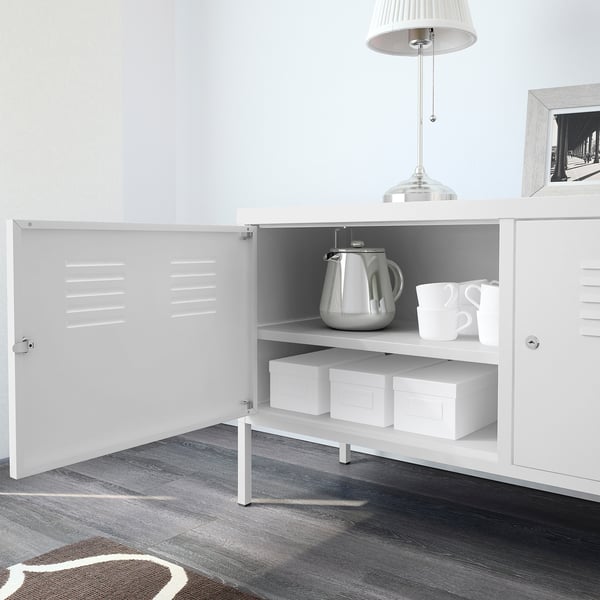 White metal cabinet with open doors revealing a silver kettle, white cups, and storage boxes on shelves.