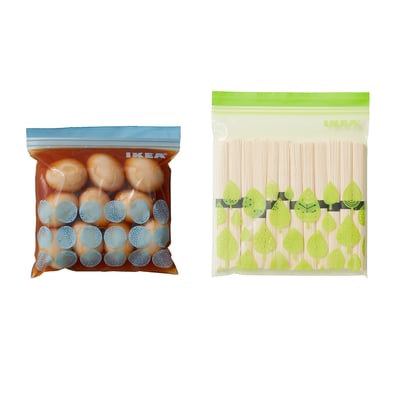 Two resealable bags by IKEA, one blue and one green, used to store and organise food or small items, keeping contents fresh.