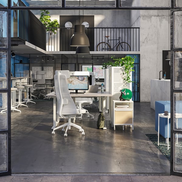 Modern office with JÄRVFJÄLLET chair, desk, bike, plants, and high ceilings.