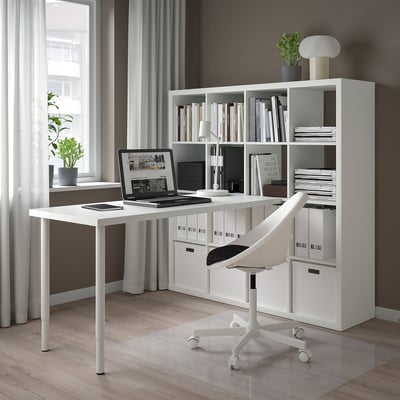 Home office with KALLAX shelves, laptop, plants, and office chair.