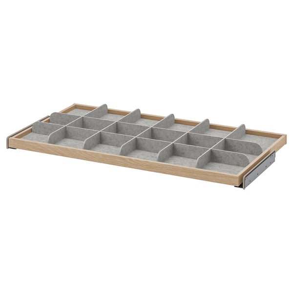 An IKEA KOMPLEMENT light grey wood drawer organiser with multiple compartments.