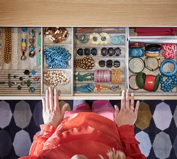 Open jewellery drawer with varied accessories organised in compartments.