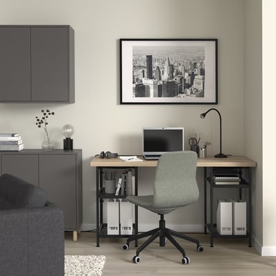 Home office with LAGKAPTEN desk, chair, lamp, and storage. Cityscape art, computer on desk.