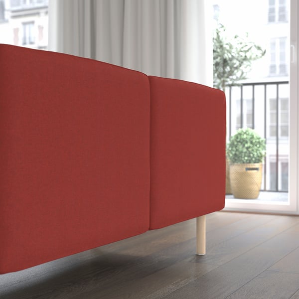 Red modular sofa near a window with a plant, offering a cosy and adaptable seating solution.