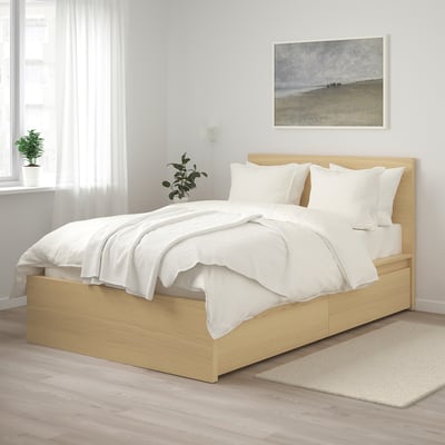Modern bedroom with light brown MALM bed, white linens, picture, and plants.