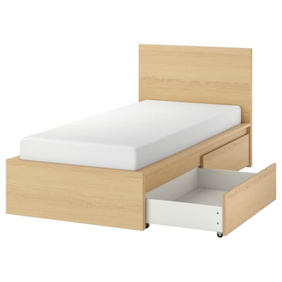 A light wooden MALM bed with a white headboard and open drawer for storage. Clean, simple design with oak finish.