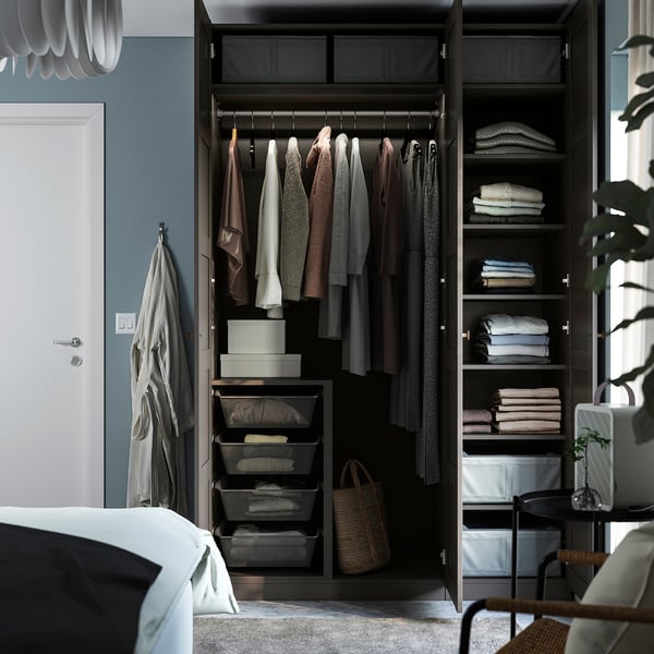 Open wardrobe displaying organised clothes, shelves, and storage bins in a bedroom setting.