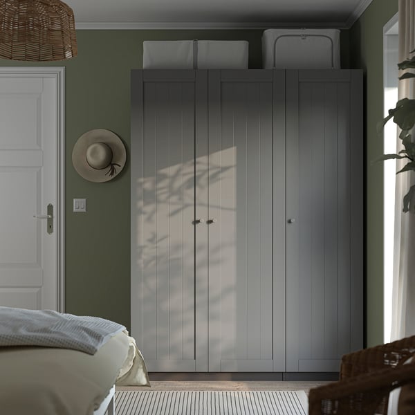 Modern bedroom with PAX wardrobe and grey doors, side door, hats, and radiator cover.