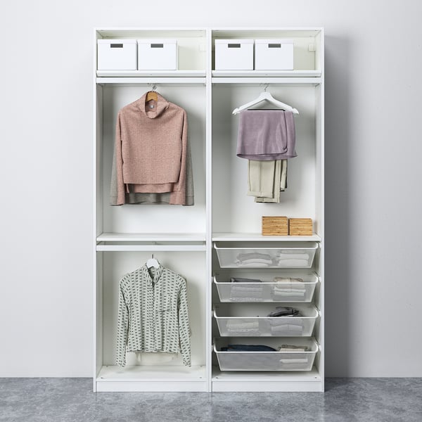 Modern white wardrobe with hanging shirts, pants, and storage baskets.