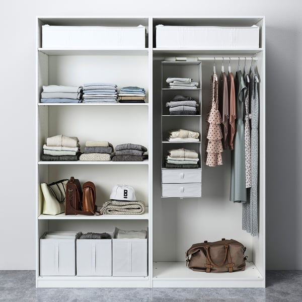 Organised closet with folded clothes, hanging garments, and storage bins. Sliding doors and multiple shelves.
