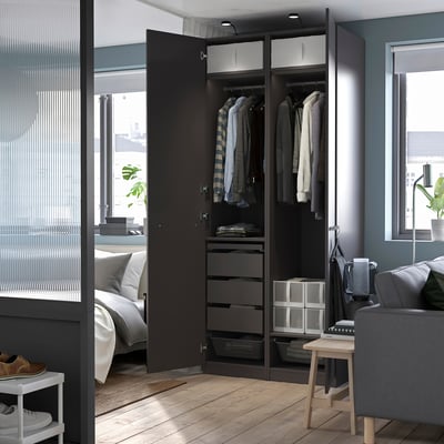 Modern black bedroom wardrobe named PAX, with hanging space, drawers, and storage, and a glass door.