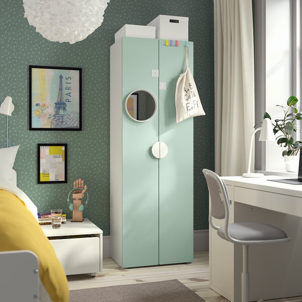 SMÅSTAD wardrobe in light green by desk, mirror, wall art, bedside table with lamp, soft light.