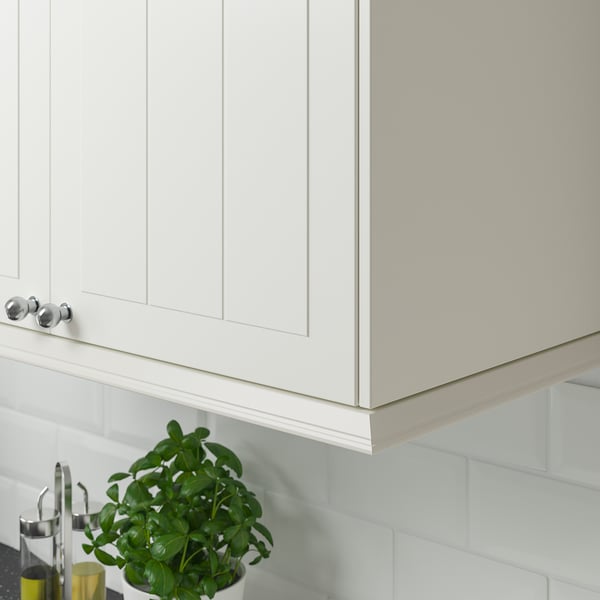 White cabinets with hidden under-lighting, chrome handles, and a green plant.