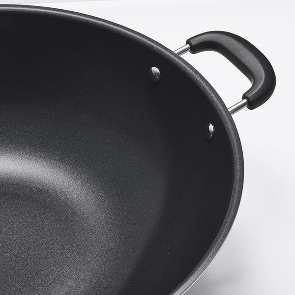 Black wok with two sturdy handles and a smooth non-stick interior, showcasing its high-quality construction.